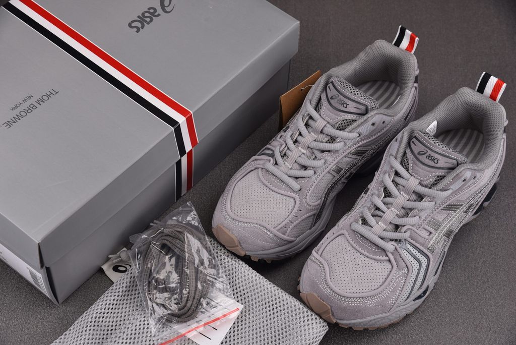 ASICS Gel-Kayano 14 x Thom Browne luxury performance sneaker in a monochromatic grey colorway, featuring premium leather and mesh construction, co-branded detailing, and metallic accents, SKU 1203B110-020.