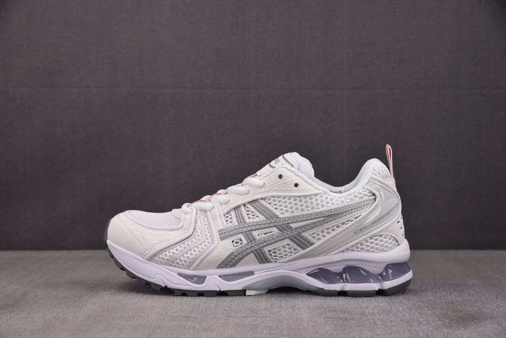 ASICS Gel-Kayano 14 x Thom Browne luxury performance sneaker in a crisp monochromatic white colorway, featuring premium leather and mesh construction, co-branded detailing, and metallic accents, SKU 1203B291-100.