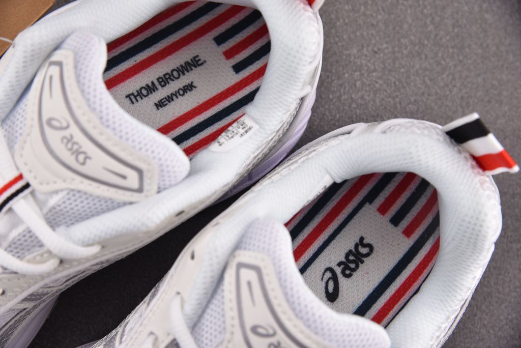 ASICS Gel-Kayano 14 x Thom Browne luxury performance sneaker in a crisp monochromatic white colorway, featuring premium leather and mesh construction, co-branded detailing, and metallic accents, SKU 1203B291-100.