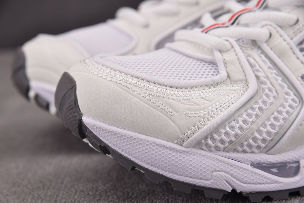 ASICS Gel-Kayano 14 x Thom Browne luxury performance sneaker in a crisp monochromatic white colorway, featuring premium leather and mesh construction, co-branded detailing, and metallic accents, SKU 1203B291-100.