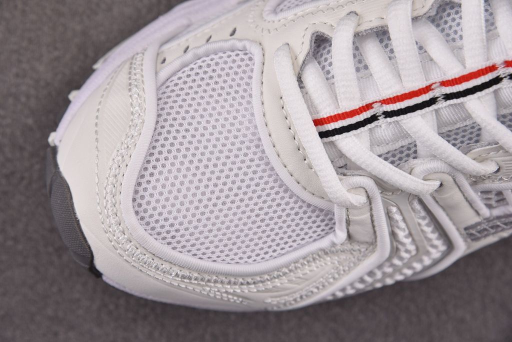 ASICS Gel-Kayano 14 x Thom Browne luxury performance sneaker in a crisp monochromatic white colorway, featuring premium leather and mesh construction, co-branded detailing, and metallic accents, SKU 1203B291-100.