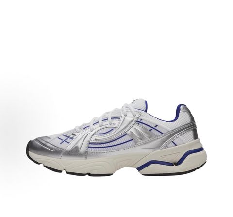Under Armour UA Sola retro tech-runner side profile, featuring a white breathable mesh upper, dynamic metallic silver synthetic overlays, and vibrant purple accents on the midsole and collar, SKU 6005284-103.