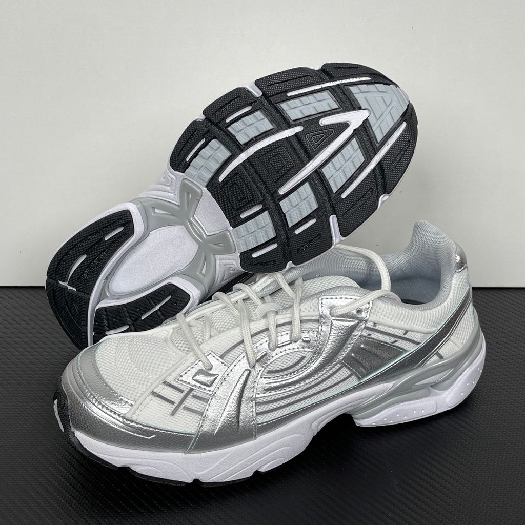 Under Armour UA Sola retro tech-runner side profile, featuring a clean white breathable mesh upper, dynamic metallic silver synthetic overlays, and a chunky white midsole, SKU 6005284-100.