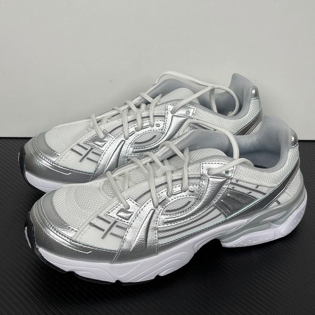 Under Armour UA Sola retro tech-runner side profile, featuring a clean white breathable mesh upper, dynamic metallic silver synthetic overlays, and a chunky white midsole, SKU 6005284-100.