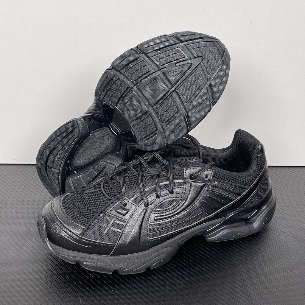 Under Armour UA Sola retro tech-runner side profile, featuring a clean triple black breathable mesh upper, dynamic tonal synthetic overlays, and a chunky black midsole, SKU 6005284-003.