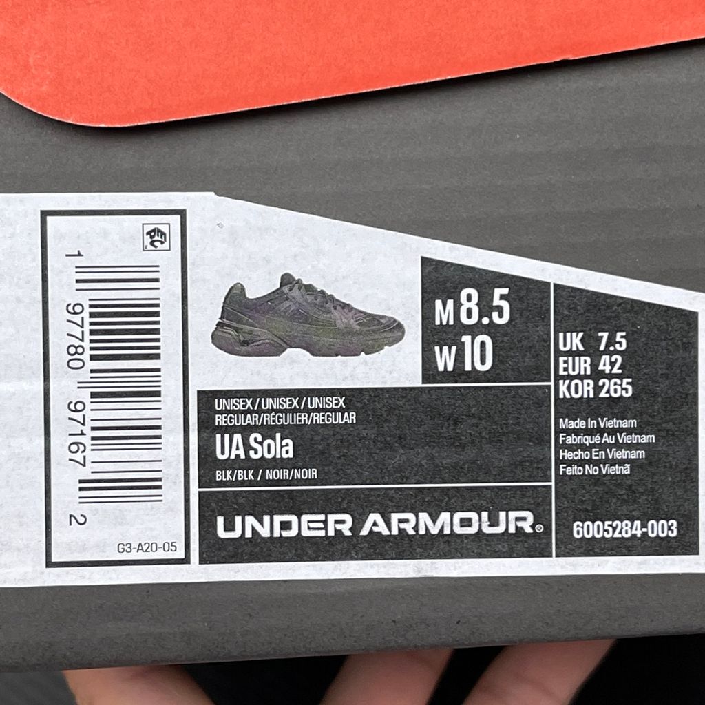 Under Armour UA Sola retro tech-runner side profile, featuring a clean triple black breathable mesh upper, dynamic tonal synthetic overlays, and a chunky black midsole, SKU 6005284-003.