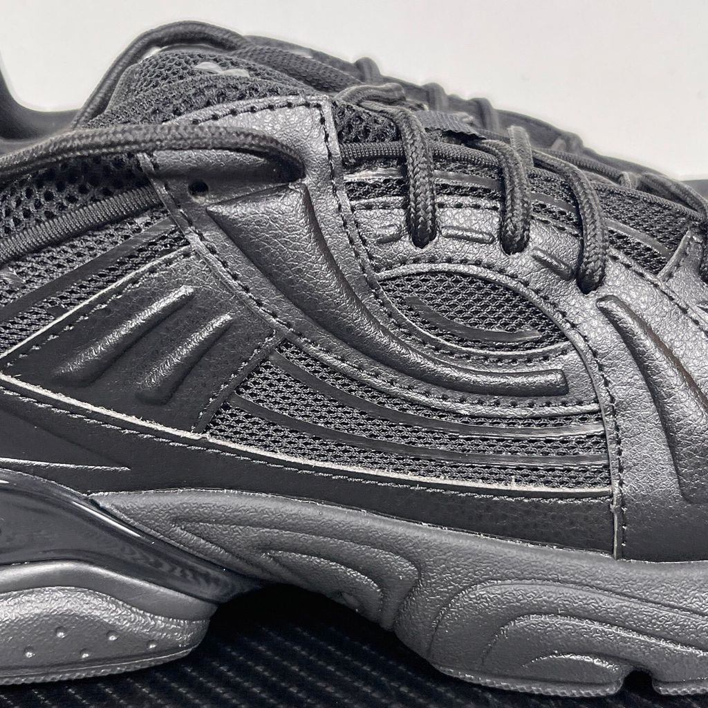 Under Armour UA Sola retro tech-runner side profile, featuring a clean triple black breathable mesh upper, dynamic tonal synthetic overlays, and a chunky black midsole, SKU 6005284-003.