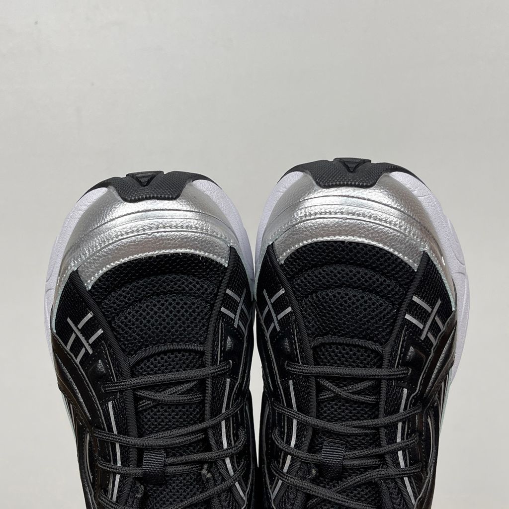 Under Armour UA Sola retro tech-runner side profile, featuring a clean black breathable mesh upper, dynamic black and metallic silver synthetic overlays, and a chunky white midsole, SKU 6005284-004.