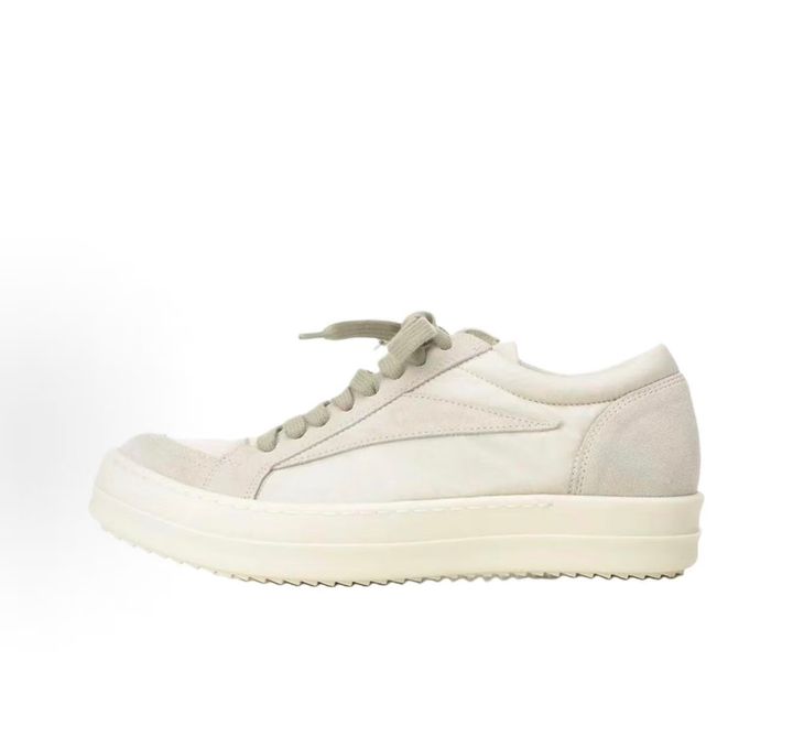 Side profile of the Rick Owens Mainline Vintage Sneaks in Pearl/Milk, featuring a sleek low-top silhouette with luxurious silk-nylon and suede spliced paneling, and a thick cream-colored outsole.