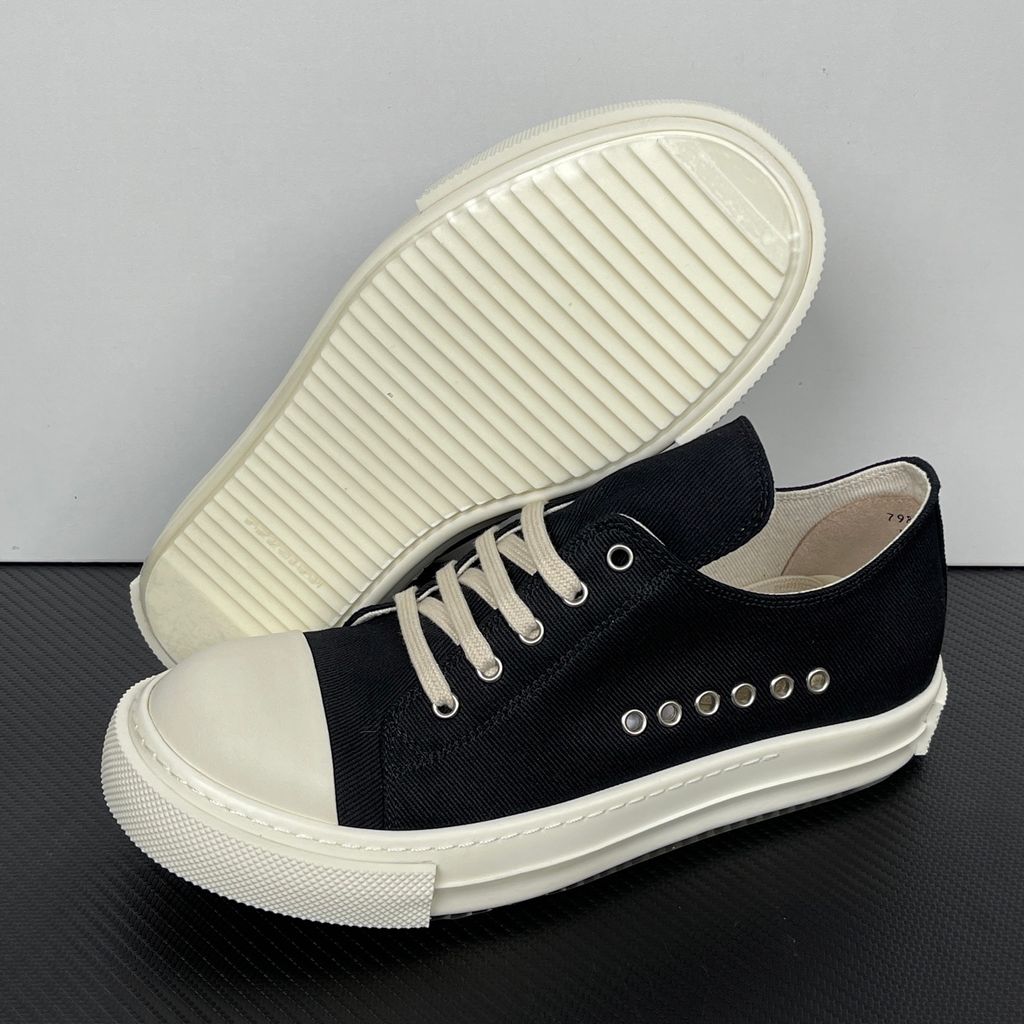 Side profile of the Rick Owens DRKSHDW Extreme Low Sneaks in Black canvas, showcasing the low-top silhouette, signature side metal eyelet row, and tonal rubber toe cap and midsole.
