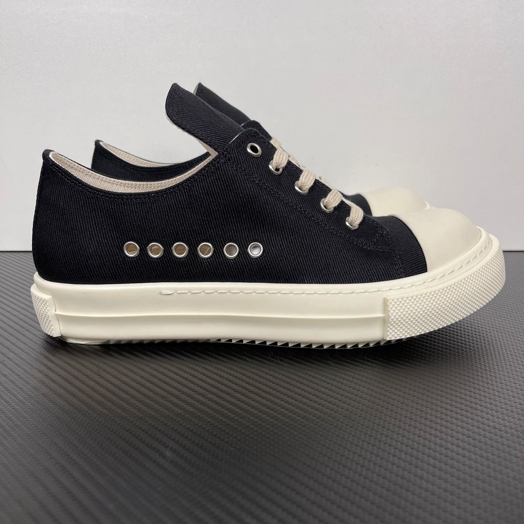 Side profile of the Rick Owens DRKSHDW Extreme Low Sneaks in Black canvas, showcasing the low-top silhouette, signature side metal eyelet row, and tonal rubber toe cap and midsole.