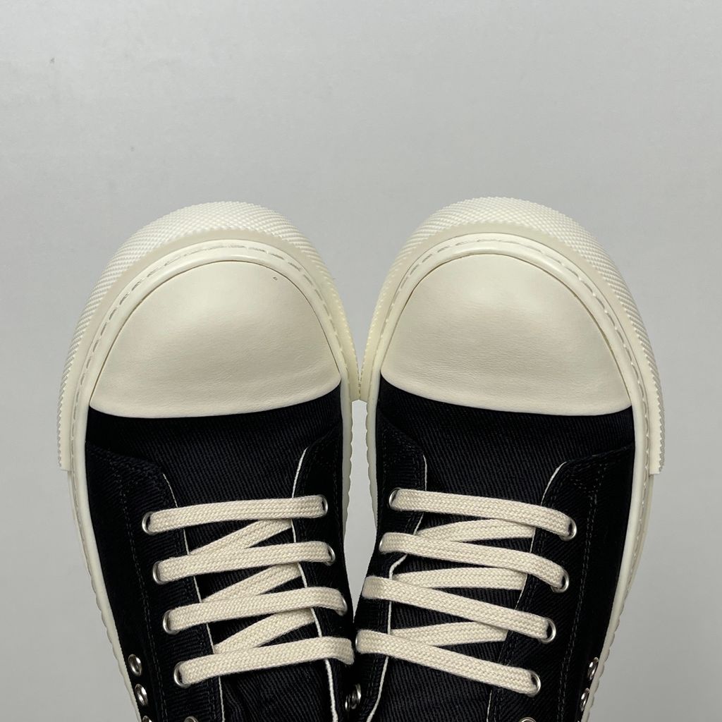 Side profile of the Rick Owens DRKSHDW Extreme Low Sneaks in Black canvas, showcasing the low-top silhouette, signature side metal eyelet row, and tonal rubber toe cap and midsole.