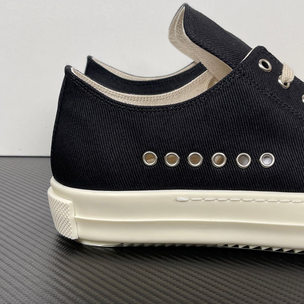 Side profile of the Rick Owens DRKSHDW Extreme Low Sneaks in Black canvas, showcasing the low-top silhouette, signature side metal eyelet row, and tonal rubber toe cap and midsole.