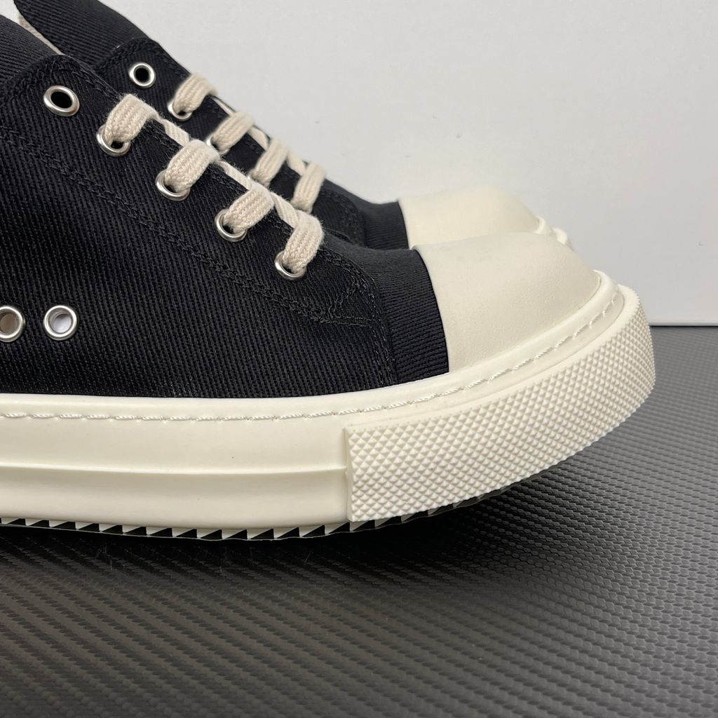 Side profile of the Rick Owens DRKSHDW Extreme Low Sneaks in Black canvas, showcasing the low-top silhouette, signature side metal eyelet row, and tonal rubber toe cap and midsole.