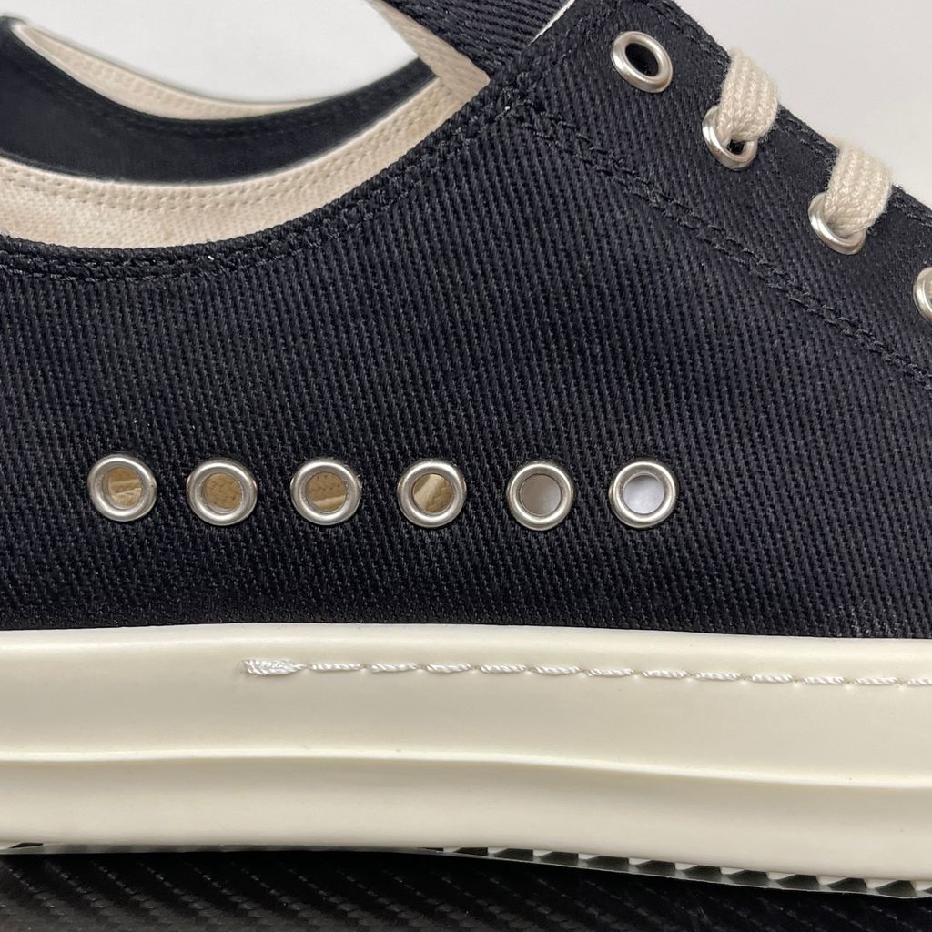 Side profile of the Rick Owens DRKSHDW Extreme Low Sneaks in Black canvas, showcasing the low-top silhouette, signature side metal eyelet row, and tonal rubber toe cap and midsole.