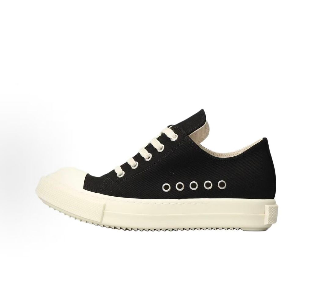 Side profile of the Rick Owens DRKSHDW Extreme Low Sneaks in Black canvas, showcasing the low-top silhouette, signature side metal eyelet row, and tonal rubber toe cap and midsole.