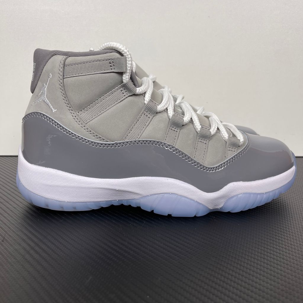 Side profile of the Air Jordan 11 Retro 'Cool Grey' (2021), showcasing the premium nubuck upper, signature high-cut grey patent leather mudguard, and white Phylon midsole.