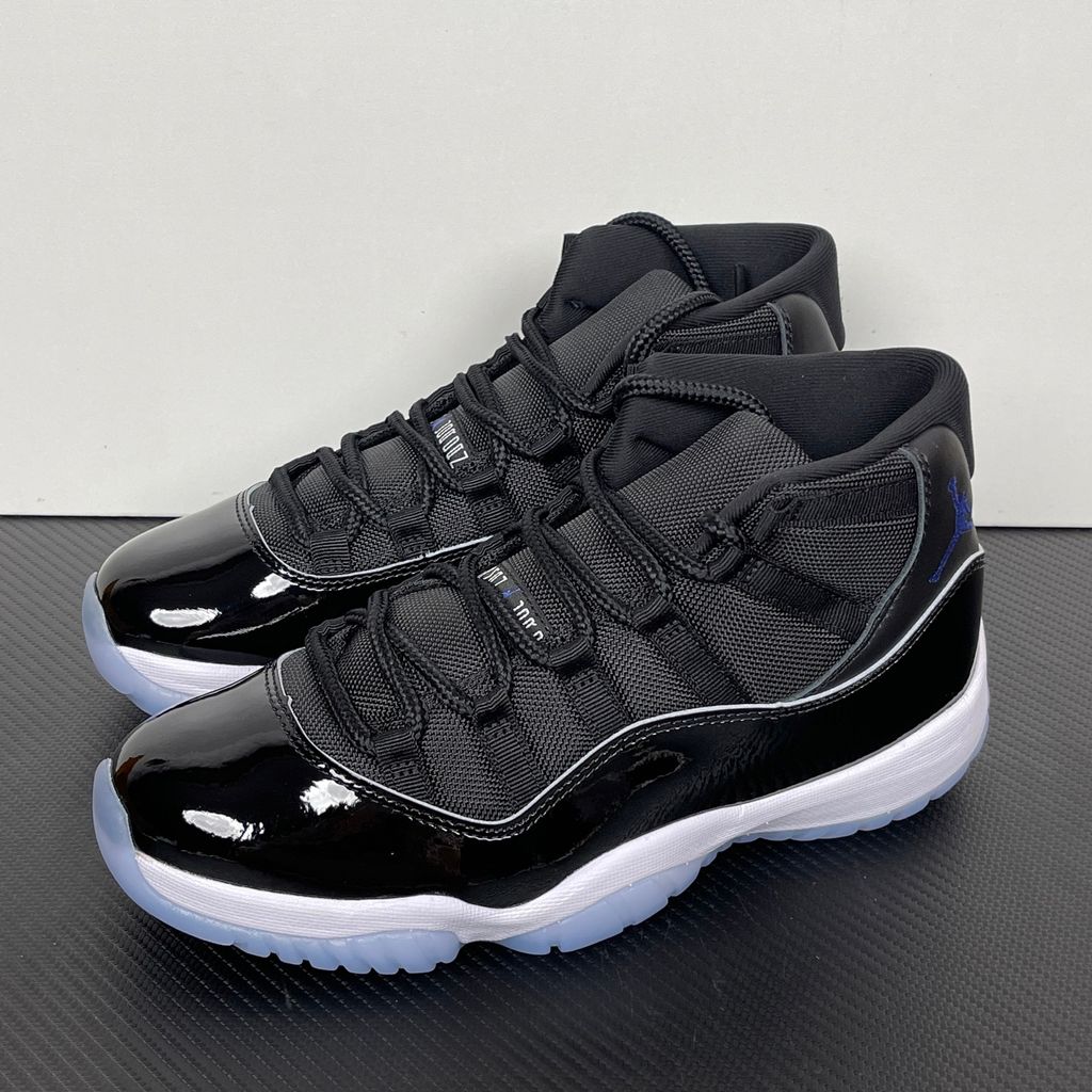 Side profile of the Air Jordan 11 Retro 'Space Jam' (2016), showcasing the black mesh upper, signature high-cut black patent leather mudguard, and crisp white Phylon midsole.