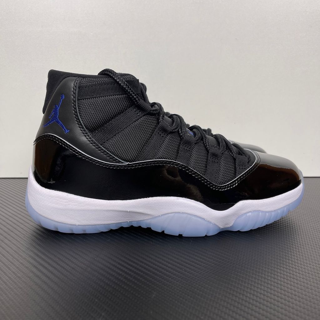 Side profile of the Air Jordan 11 Retro 'Space Jam' (2016), showcasing the black mesh upper, signature high-cut black patent leather mudguard, and crisp white Phylon midsole.