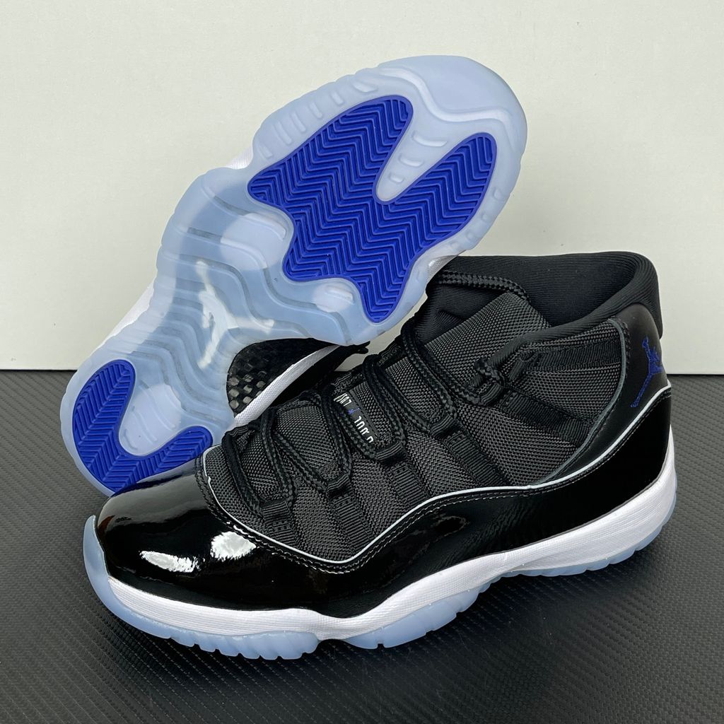 Side profile of the Air Jordan 11 Retro 'Space Jam' (2016), showcasing the black mesh upper, signature high-cut black patent leather mudguard, and crisp white Phylon midsole.