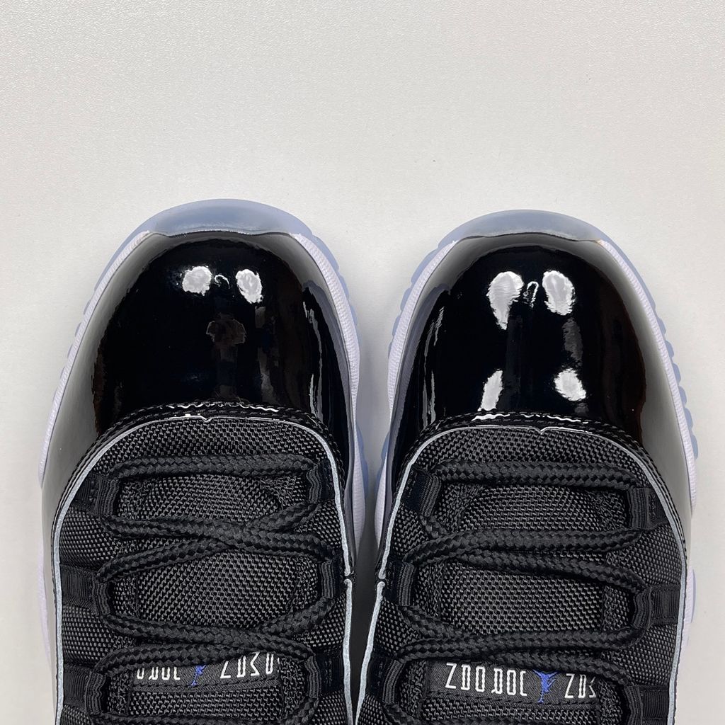 Side profile of the Air Jordan 11 Retro 'Space Jam' (2016), showcasing the black mesh upper, signature high-cut black patent leather mudguard, and crisp white Phylon midsole.