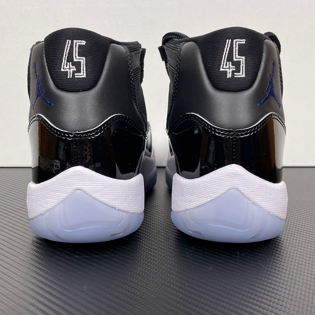 Side profile of the Air Jordan 11 Retro 'Space Jam' (2016), showcasing the black mesh upper, signature high-cut black patent leather mudguard, and crisp white Phylon midsole.