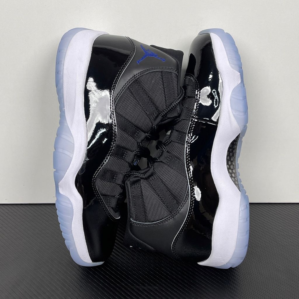 Side profile of the Air Jordan 11 Retro 'Space Jam' (2016), showcasing the black mesh upper, signature high-cut black patent leather mudguard, and crisp white Phylon midsole.