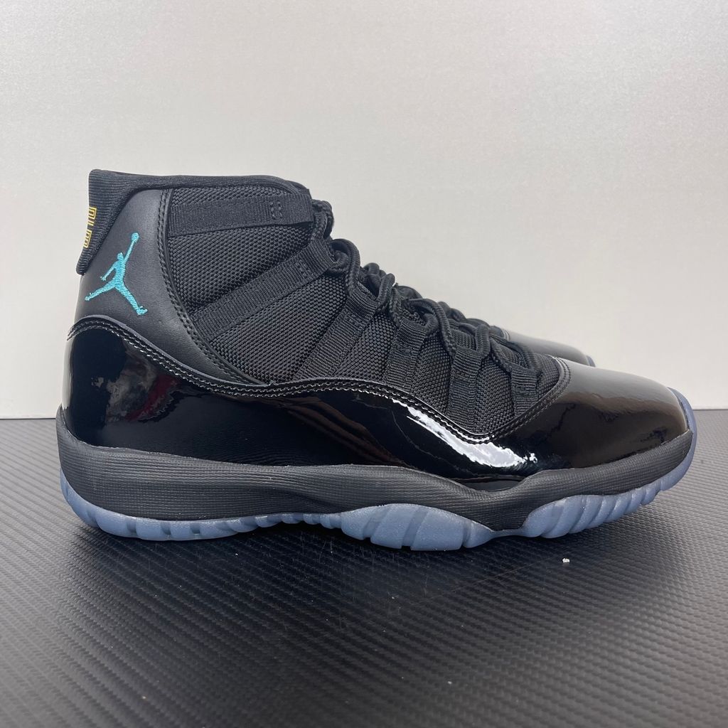 Side profile of the Air Jordan 11 Retro 'Gamma Blue' (2025), showcasing the all-black ballistic mesh upper, glossy high-cut patent leather mudguard, and black Phylon midsole.
