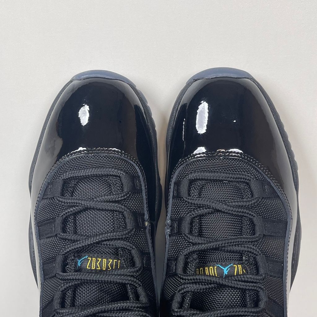 Side profile of the Air Jordan 11 Retro 'Gamma Blue' (2025), showcasing the all-black ballistic mesh upper, glossy high-cut patent leather mudguard, and black Phylon midsole.