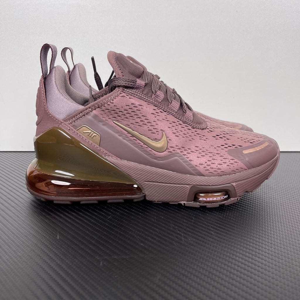 Side profile of the Nike Air Max 270 Premium 'Tattoo' in Metallic Red Bronze, showcasing the shimmering metallic upper, detailed tattoo-inspired graphic overlays, and the massive translucent Max Air unit.