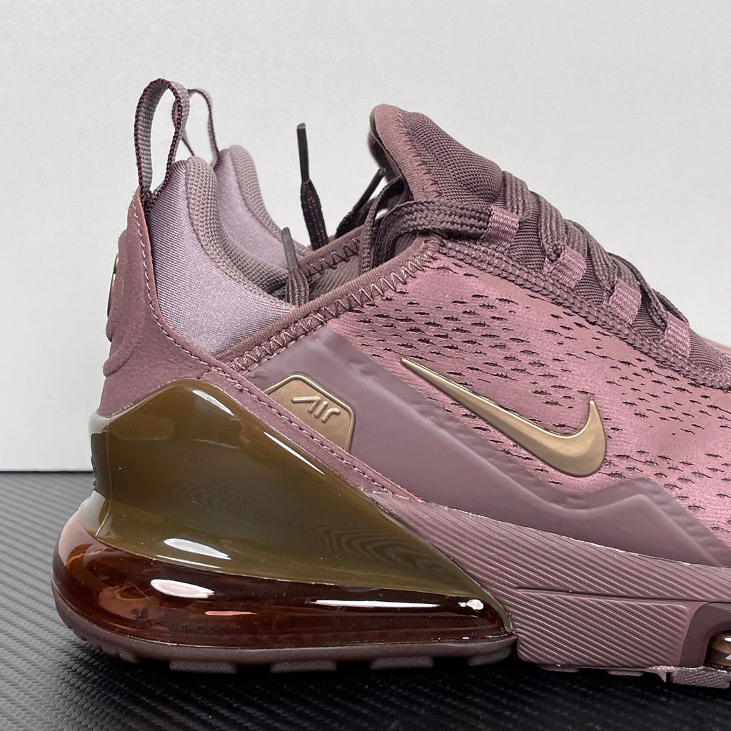 Side profile of the Nike Air Max 270 Premium 'Tattoo' in Metallic Red Bronze, showcasing the shimmering metallic upper, detailed tattoo-inspired graphic overlays, and the massive translucent Max Air unit.