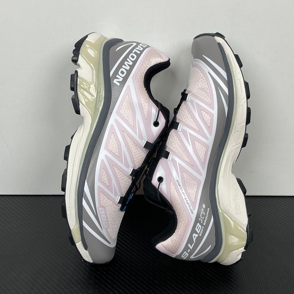 Side profile of the Salomon XT-6 trainers in a grey, white, and soft pink colorway, showcasing the technical mesh upper, "LAB" branding, and the cushioned ACS midsole.