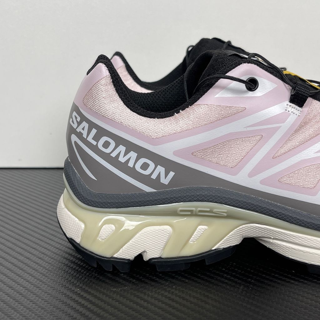 Side profile of the Salomon XT-6 trainers in a grey, white, and soft pink colorway, showcasing the technical mesh upper, "LAB" branding, and the cushioned ACS midsole.