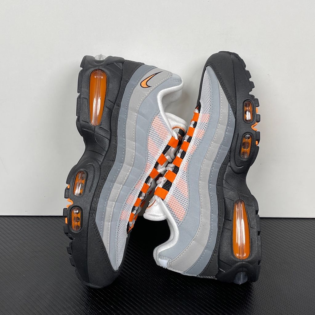 Side profile of the Nike Air Max 95 OG 'Big Bubble' Bright Mandarin 2.0, showcasing the signature layered gradient upper, vibrant orange eyelets and branding, and the enlarged visible Air unit in the heel.