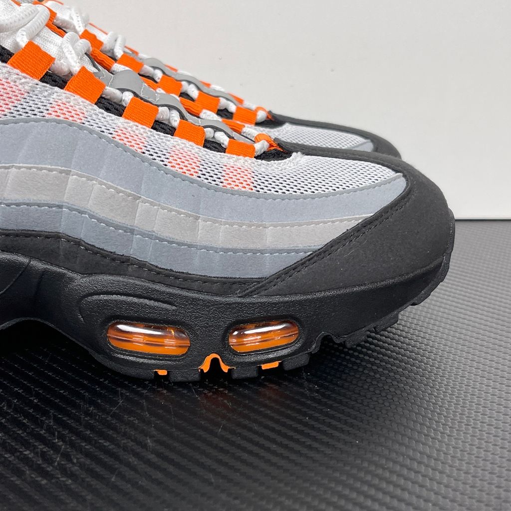Side profile of the Nike Air Max 95 OG 'Big Bubble' Bright Mandarin 2.0, showcasing the signature layered gradient upper, vibrant orange eyelets and branding, and the enlarged visible Air unit in the heel.