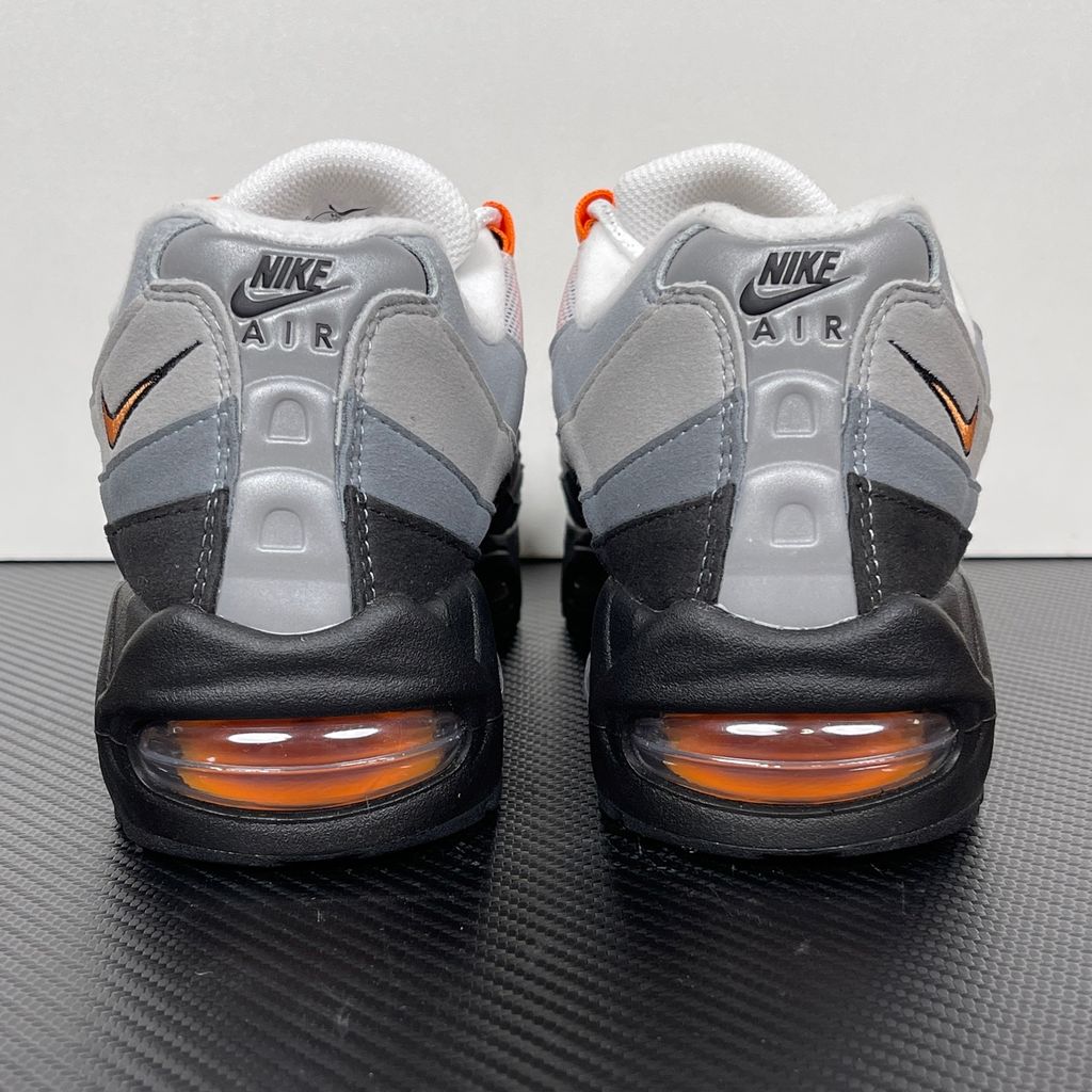 Side profile of the Nike Air Max 95 OG 'Big Bubble' Bright Mandarin 2.0, showcasing the signature layered gradient upper, vibrant orange eyelets and branding, and the enlarged visible Air unit in the heel.