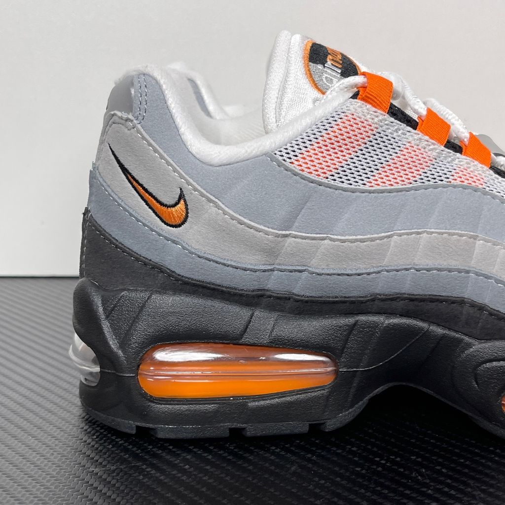 Side profile of the Nike Air Max 95 OG 'Big Bubble' Bright Mandarin 2.0, showcasing the signature layered gradient upper, vibrant orange eyelets and branding, and the enlarged visible Air unit in the heel.