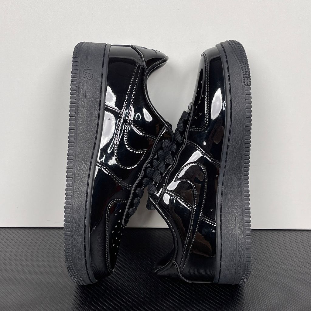 Side profile of the Nike Air Force 1 Low '07 Premium 'Black Patent', showcasing the high-gloss all-black patent leather upper, tonal Swoosh, and classic black rubber midsole.