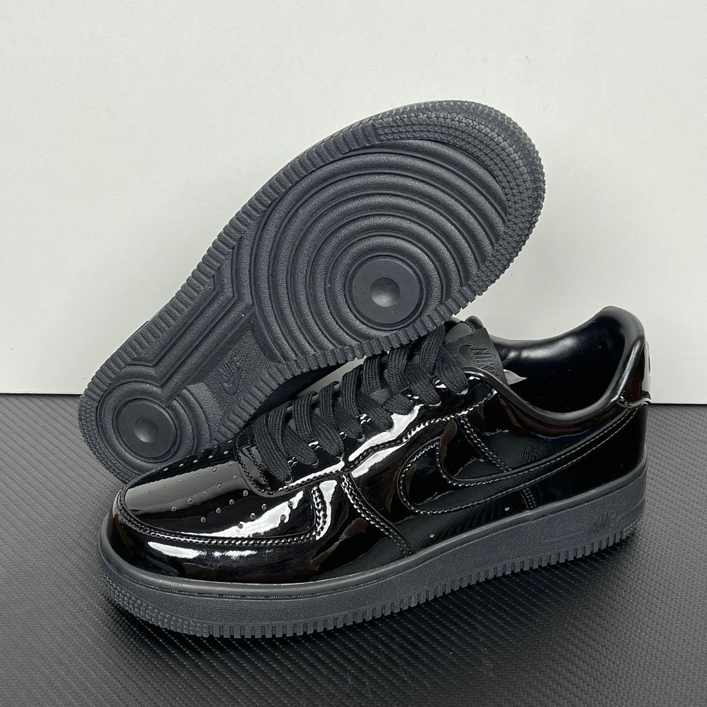 Side profile of the Nike Air Force 1 Low '07 Premium 'Black Patent', showcasing the high-gloss all-black patent leather upper, tonal Swoosh, and classic black rubber midsole.