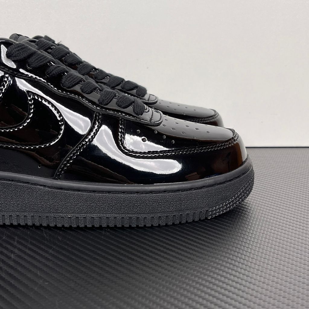 Side profile of the Nike Air Force 1 Low '07 Premium 'Black Patent', showcasing the high-gloss all-black patent leather upper, tonal Swoosh, and classic black rubber midsole.