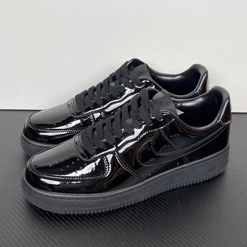 Side profile of the Nike Air Force 1 Low '07 Premium 'Black Patent', showcasing the high-gloss all-black patent leather upper, tonal Swoosh, and classic black rubber midsole.