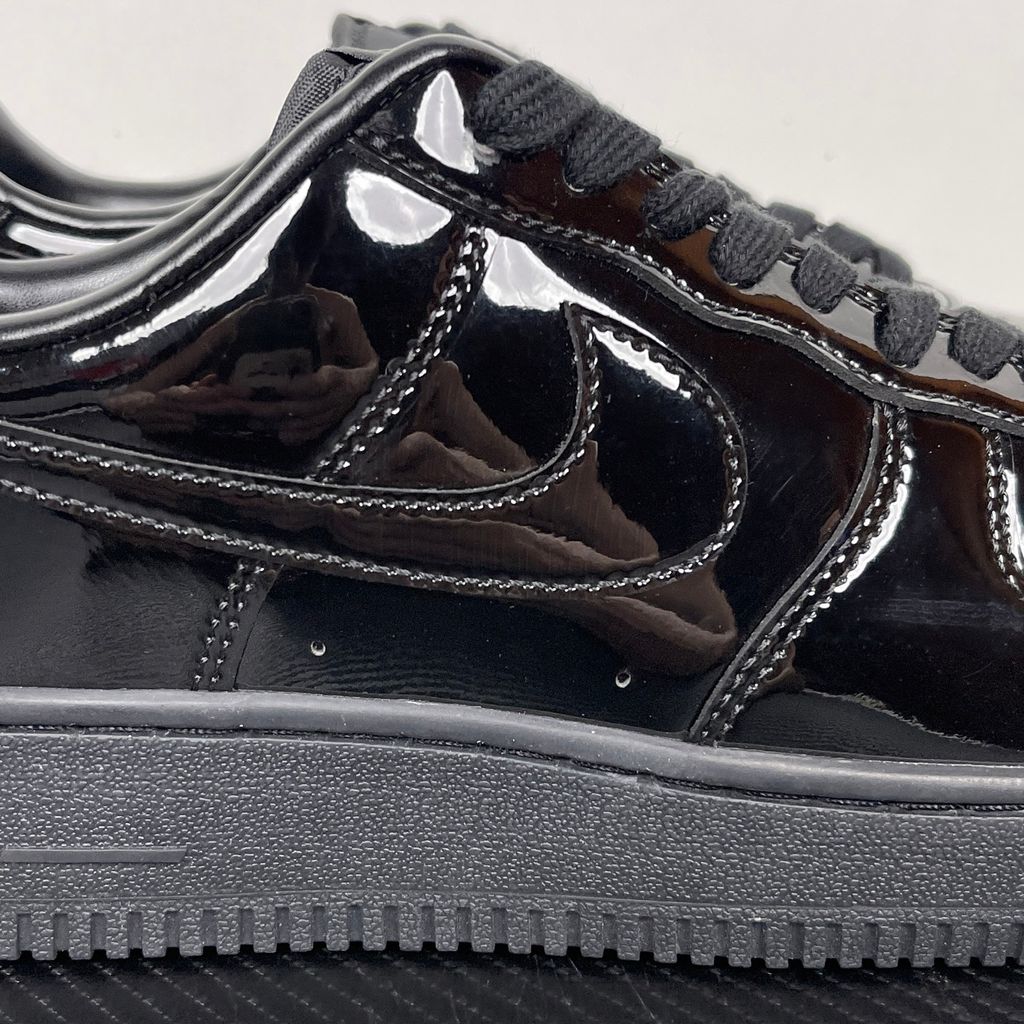 Side profile of the Nike Air Force 1 Low '07 Premium 'Black Patent', showcasing the high-gloss all-black patent leather upper, tonal Swoosh, and classic black rubber midsole.