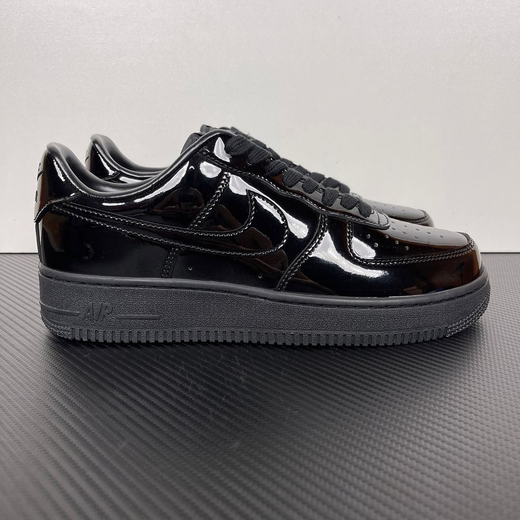 Side profile of the Nike Air Force 1 Low '07 Premium 'Black Patent', showcasing the high-gloss all-black patent leather upper, tonal Swoosh, and classic black rubber midsole.