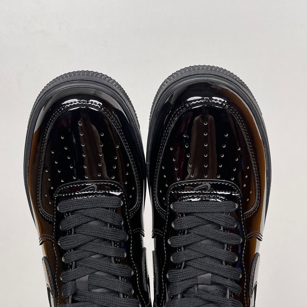 Side profile of the Nike Air Force 1 Low '07 Premium 'Black Patent', showcasing the high-gloss all-black patent leather upper, tonal Swoosh, and classic black rubber midsole.