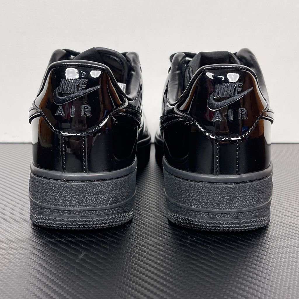 Side profile of the Nike Air Force 1 Low '07 Premium 'Black Patent', showcasing the high-gloss all-black patent leather upper, tonal Swoosh, and classic black rubber midsole.