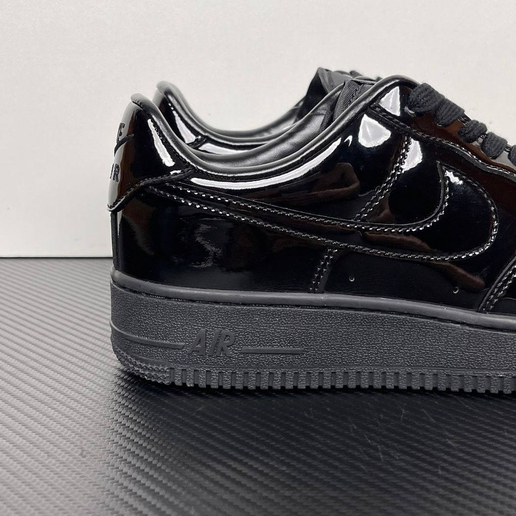 Side profile of the Nike Air Force 1 Low '07 Premium 'Black Patent', showcasing the high-gloss all-black patent leather upper, tonal Swoosh, and classic black rubber midsole.