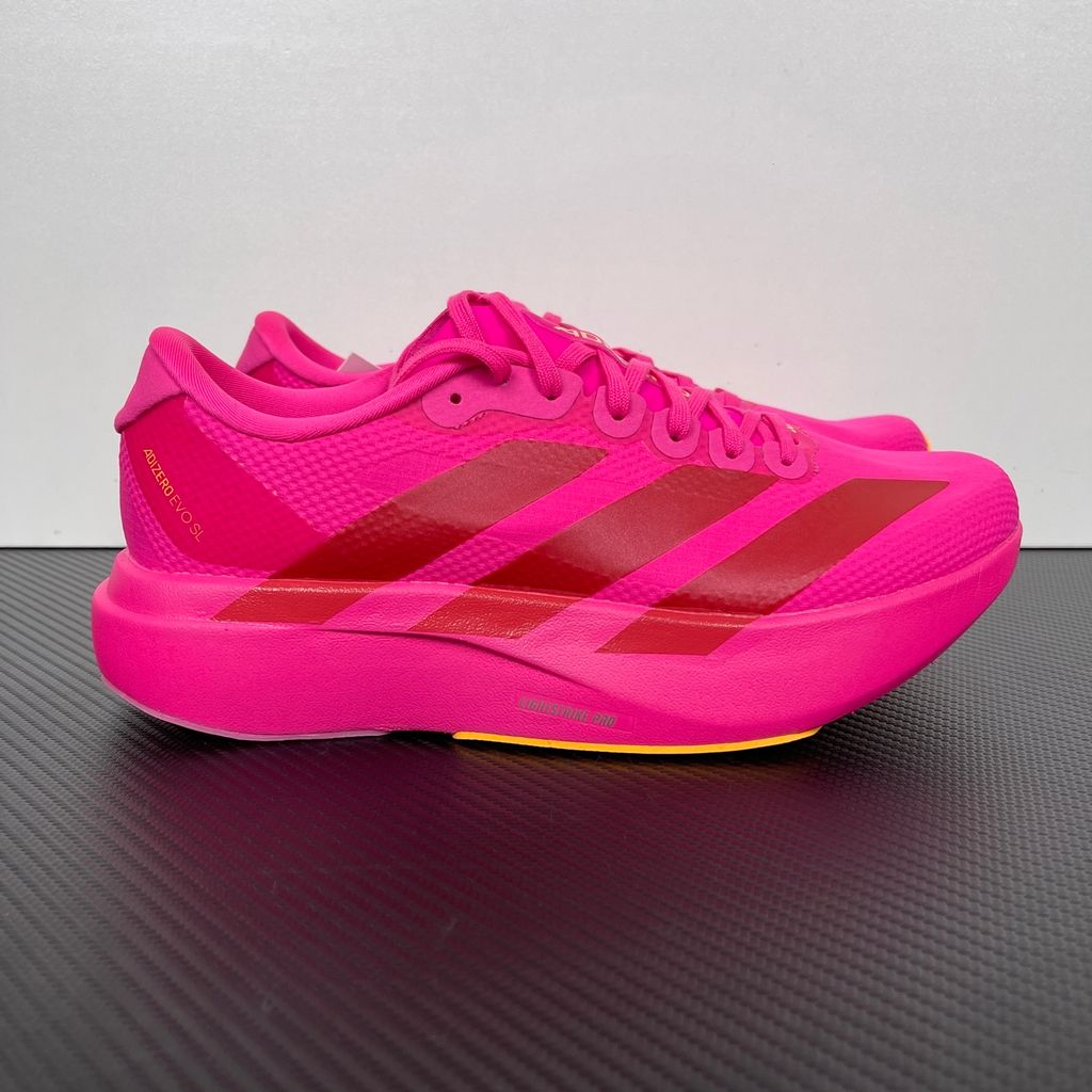 Side profile of the adidas Adizero Evo SL in a vibrant Watermelon Red colorway, showcasing the lightweight mesh upper, bold red 3-Stripes branding across the midfoot, and the thick, responsive Lightstrike Pro cushioned midsole.