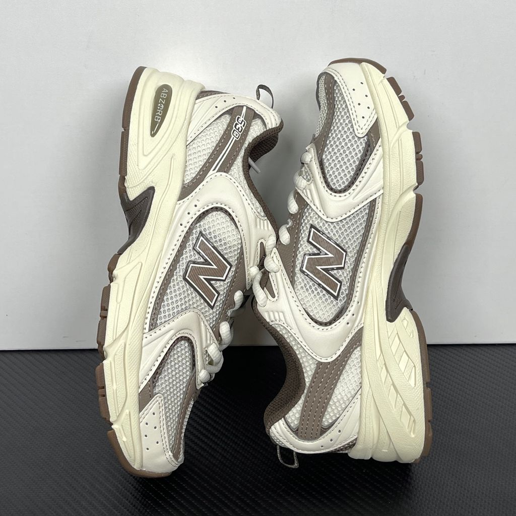 Side profile of the New Balance 530 'Turtledove Mushroom', showcasing the breathable cream mesh upper, earthy mushroom brown synthetic overlays, classic 'N' logo, and the chunky ABZORB cushioned midsole.
