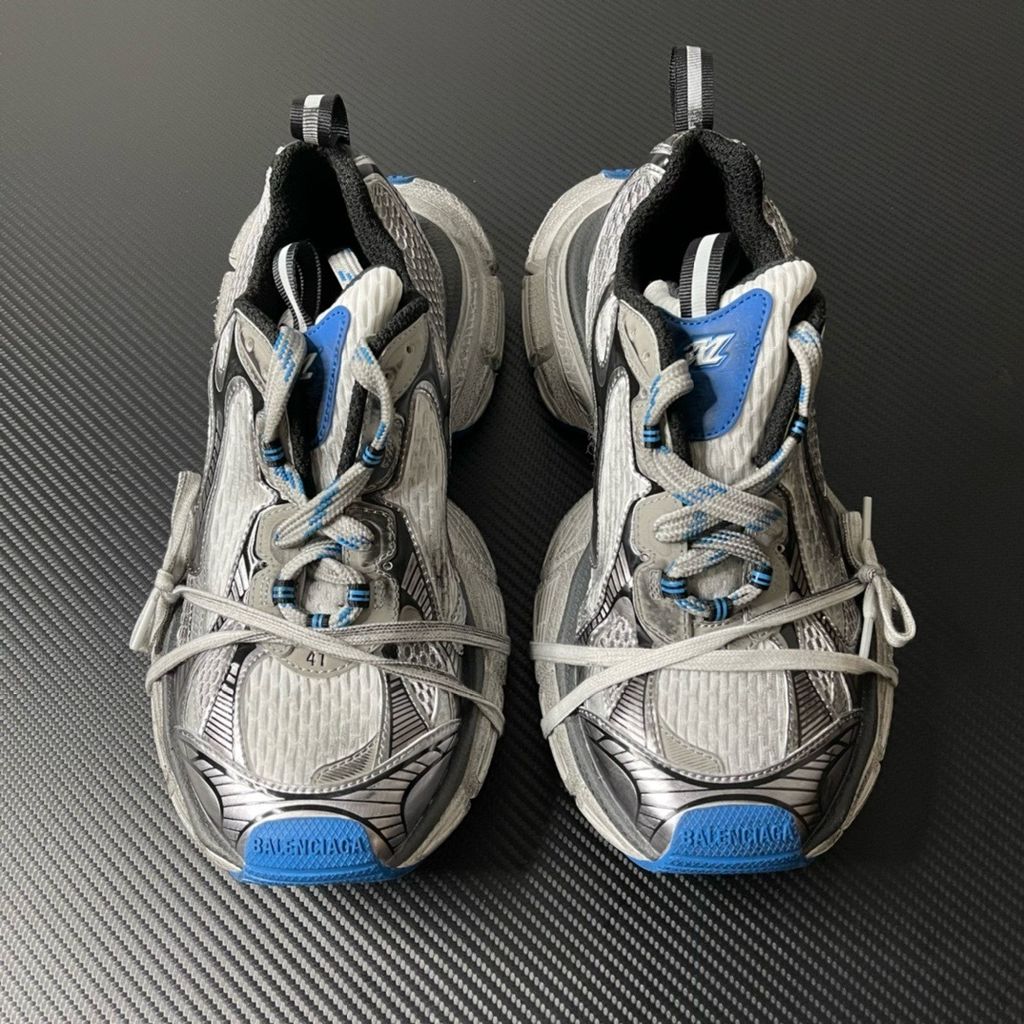 Side profile of the Balenciaga 3XL "Worn-Out Grey Blue" sneaker, highlighting the signature distressed finish, intricate layered mesh and synthetic overlays, and the exaggerated, sculpted chunky midsole.