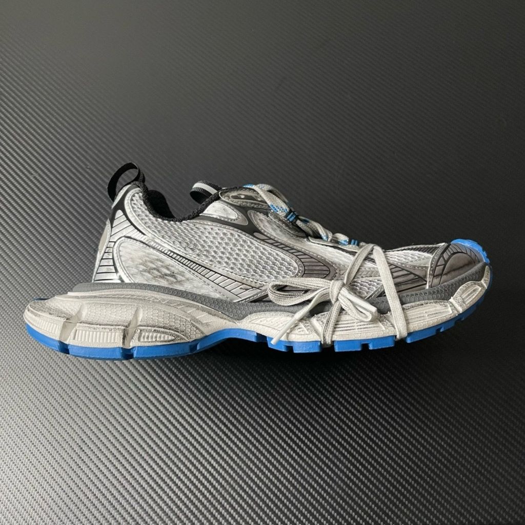 Side profile of the Balenciaga 3XL "Worn-Out Grey Blue" sneaker, highlighting the signature distressed finish, intricate layered mesh and synthetic overlays, and the exaggerated, sculpted chunky midsole.